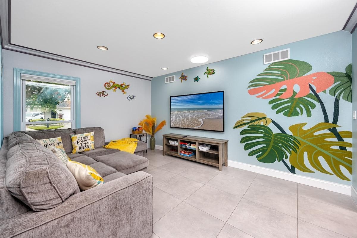 Enjoy watching TV or playing games with friends & family in our tropical-themed living room. Relax on a large sectional sofa while enjoying our 75” smart Roku TV. We also provide games, toys, books, coloring books, & crayons for the kids to have fun!